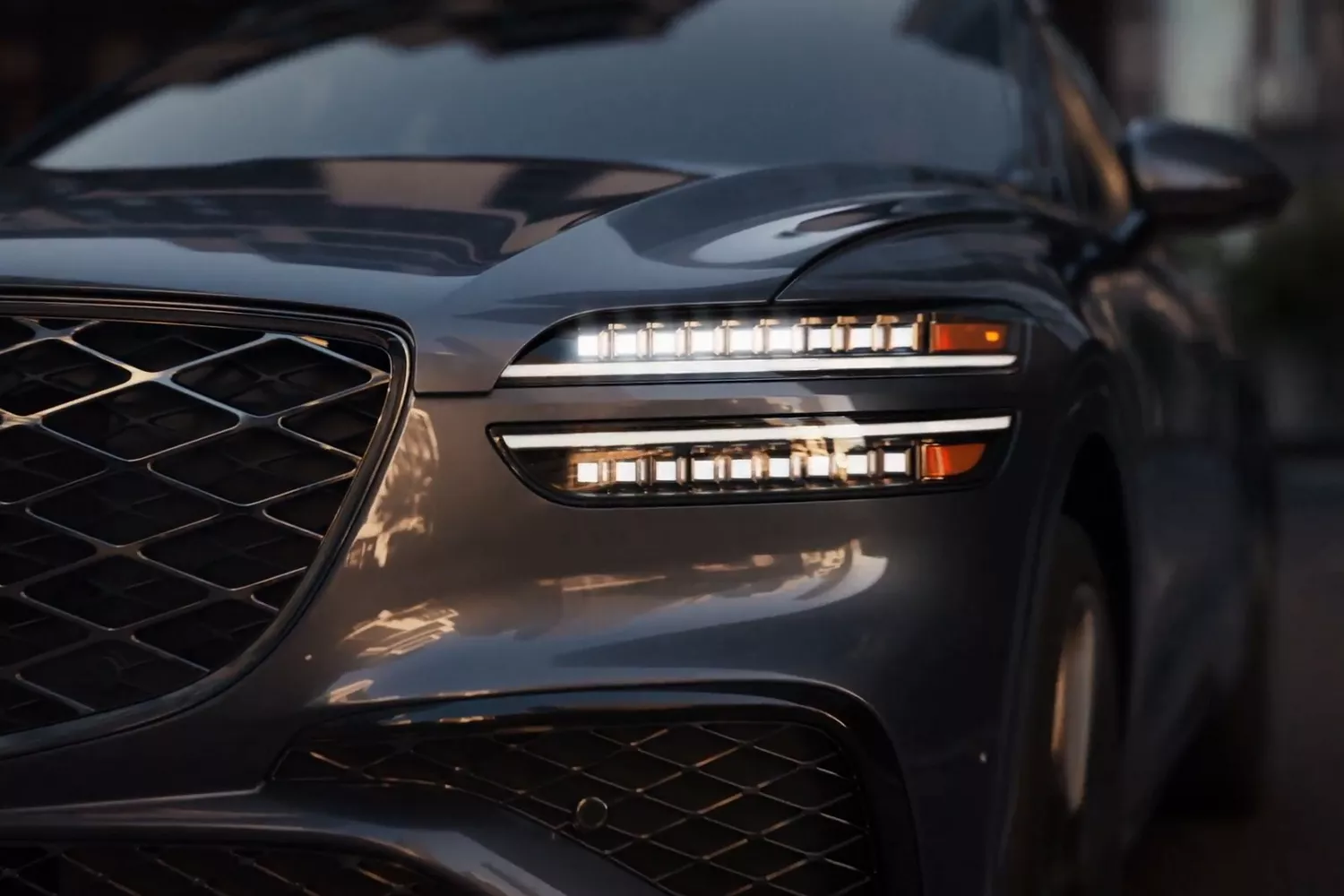 A close-up view of a sleek, 2026 Genesis GV70 with distinctive LED headlights and a stylish grille.