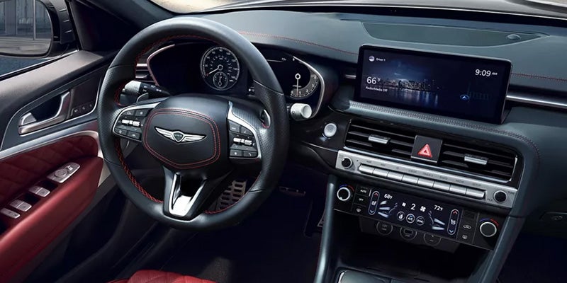 A close-up of a Genesis logo on a blue car