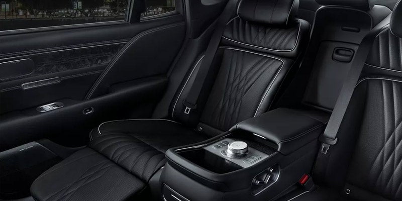The rear interior of a car with black leather seats.