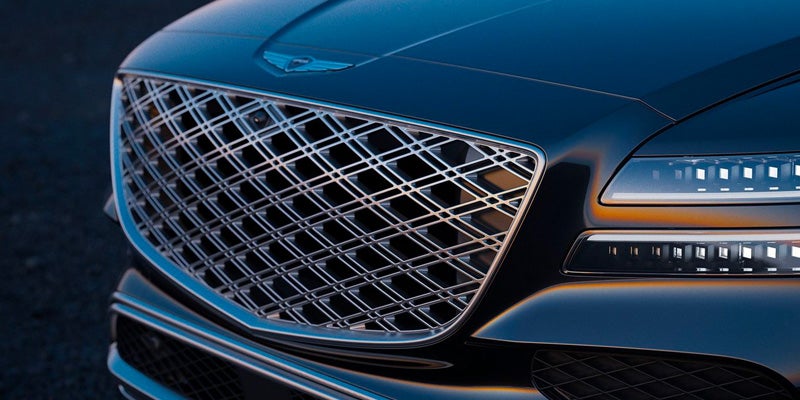 A close-up of a blue car's front grille and headlights