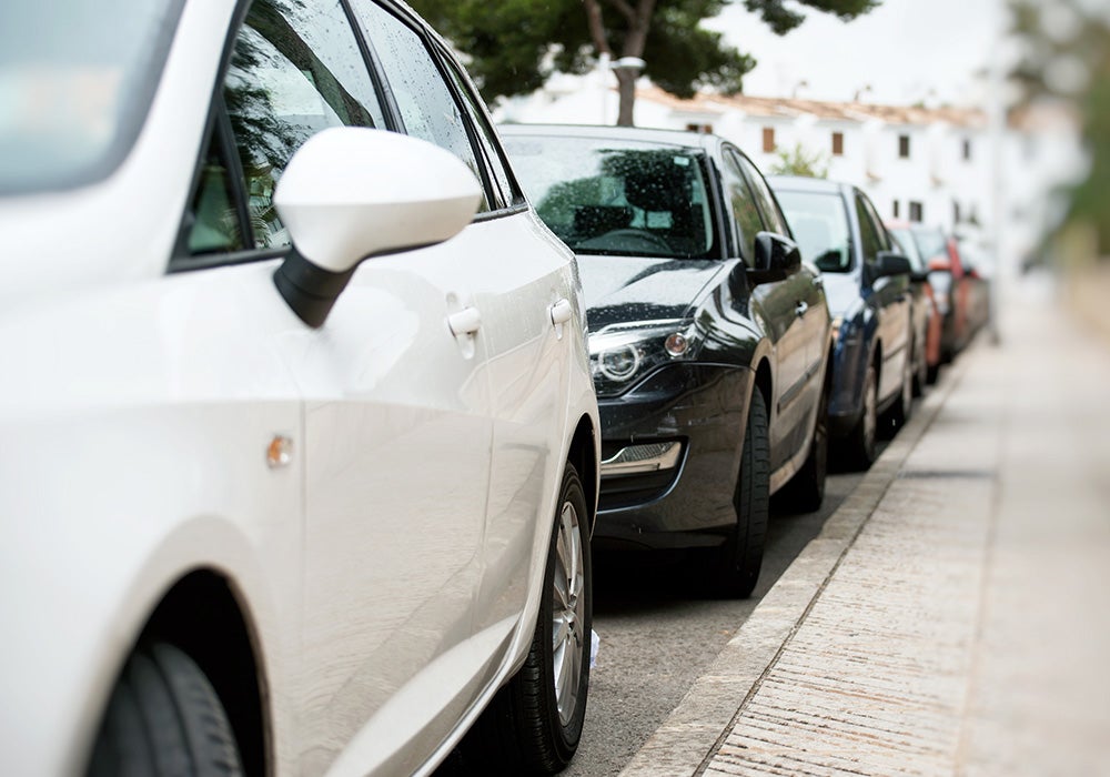 Row of cars parked by walkway